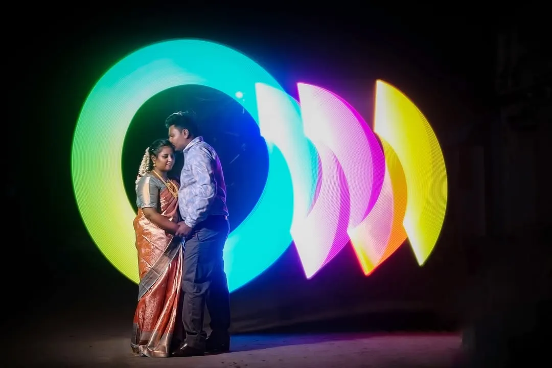I create magic with light. This is a special technique called light painting, where I use long exposure photography to draw vibrant colors in the air around you, creating a one-of-a-kind portrait for this couple.