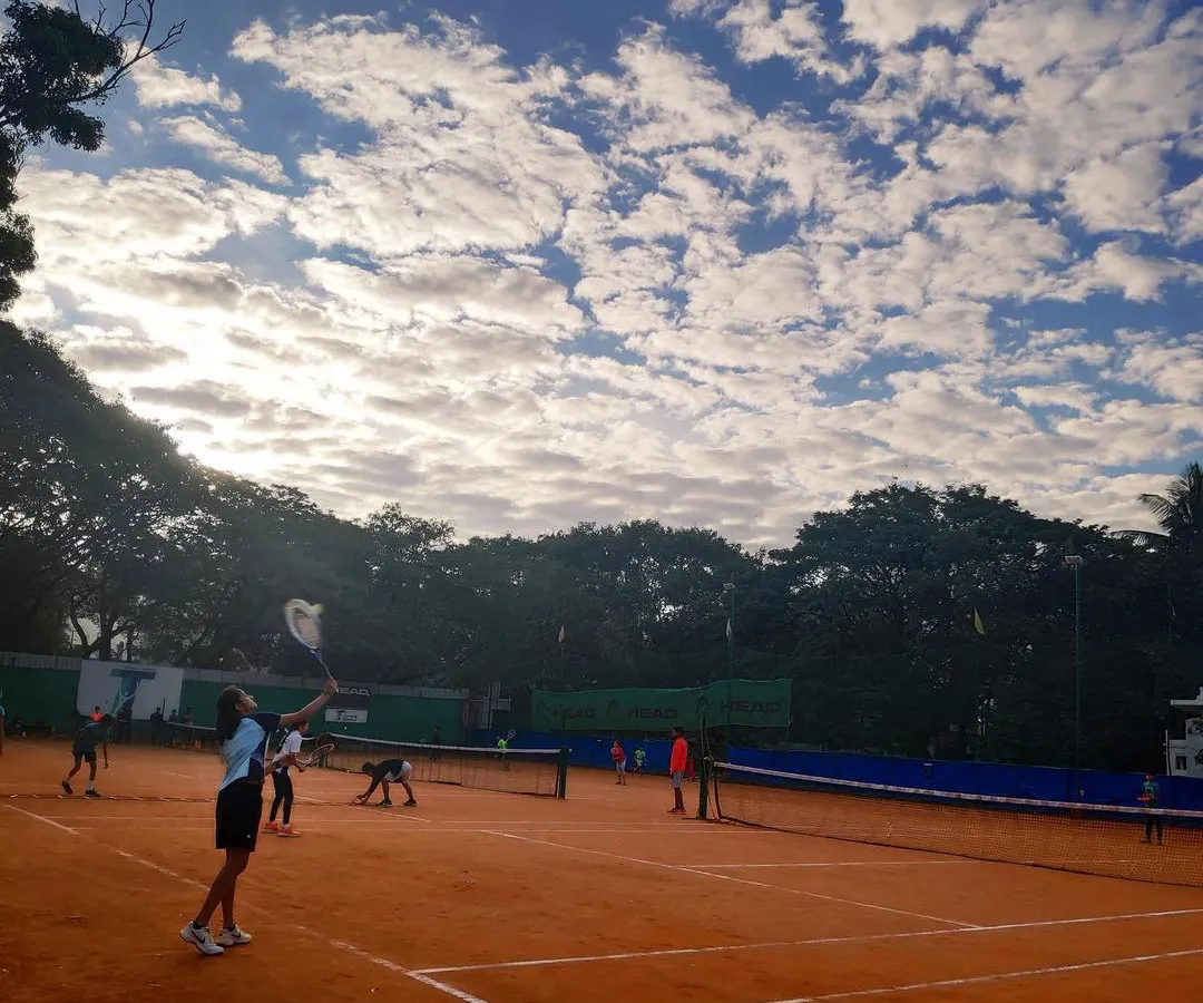 A stunning view of our green clay courts under a beautiful sky. This is where your tennis journey begins, surrounded by nature and a passion for the game.