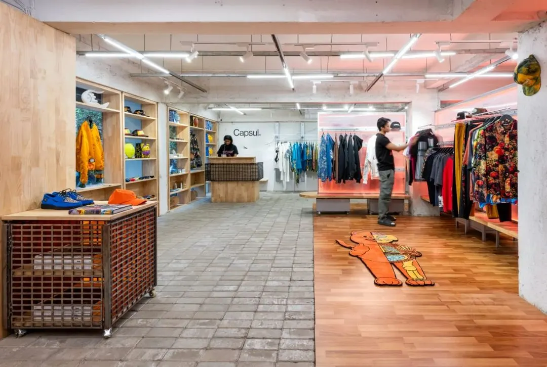 For Capsul in Mumbai, we transformed a former bank into a gritty, adaptive retail environment. The design uses raw materials like concrete pavers and wood, creating distinct zones that encourage exploration, while a custom lighting grid sets a dynamic, urban mood.