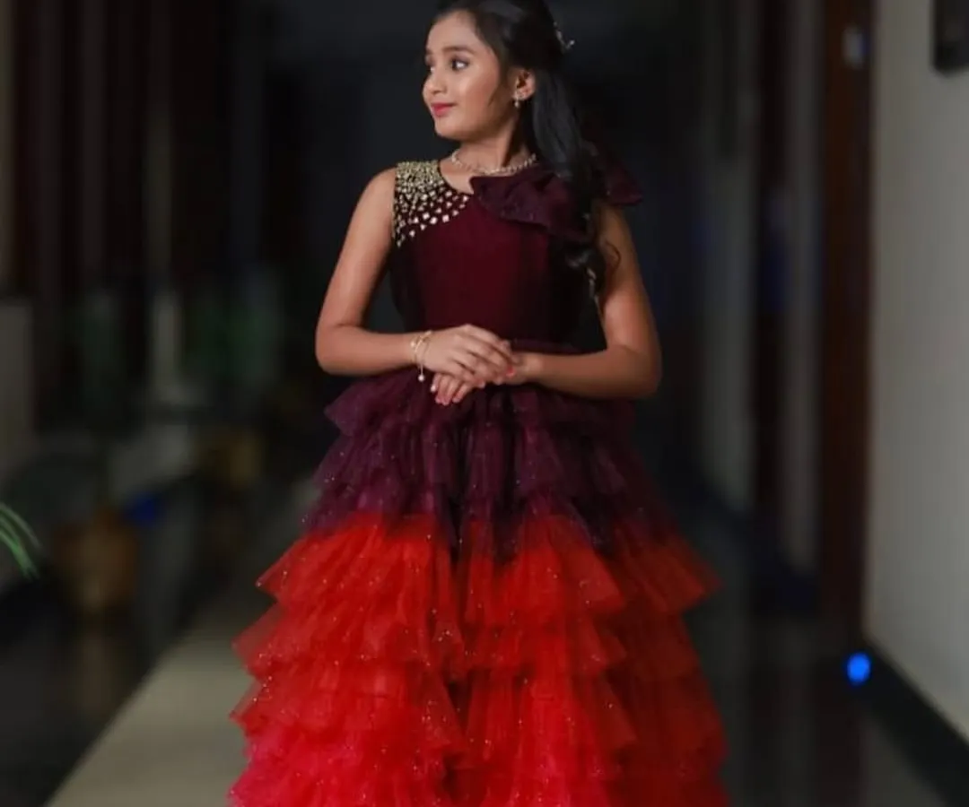 I designed this multi-layered gown with shades of wine, red, and pink for a special 10th birthday party. The bodice features delicate beadwork for an extra touch of sparkle.