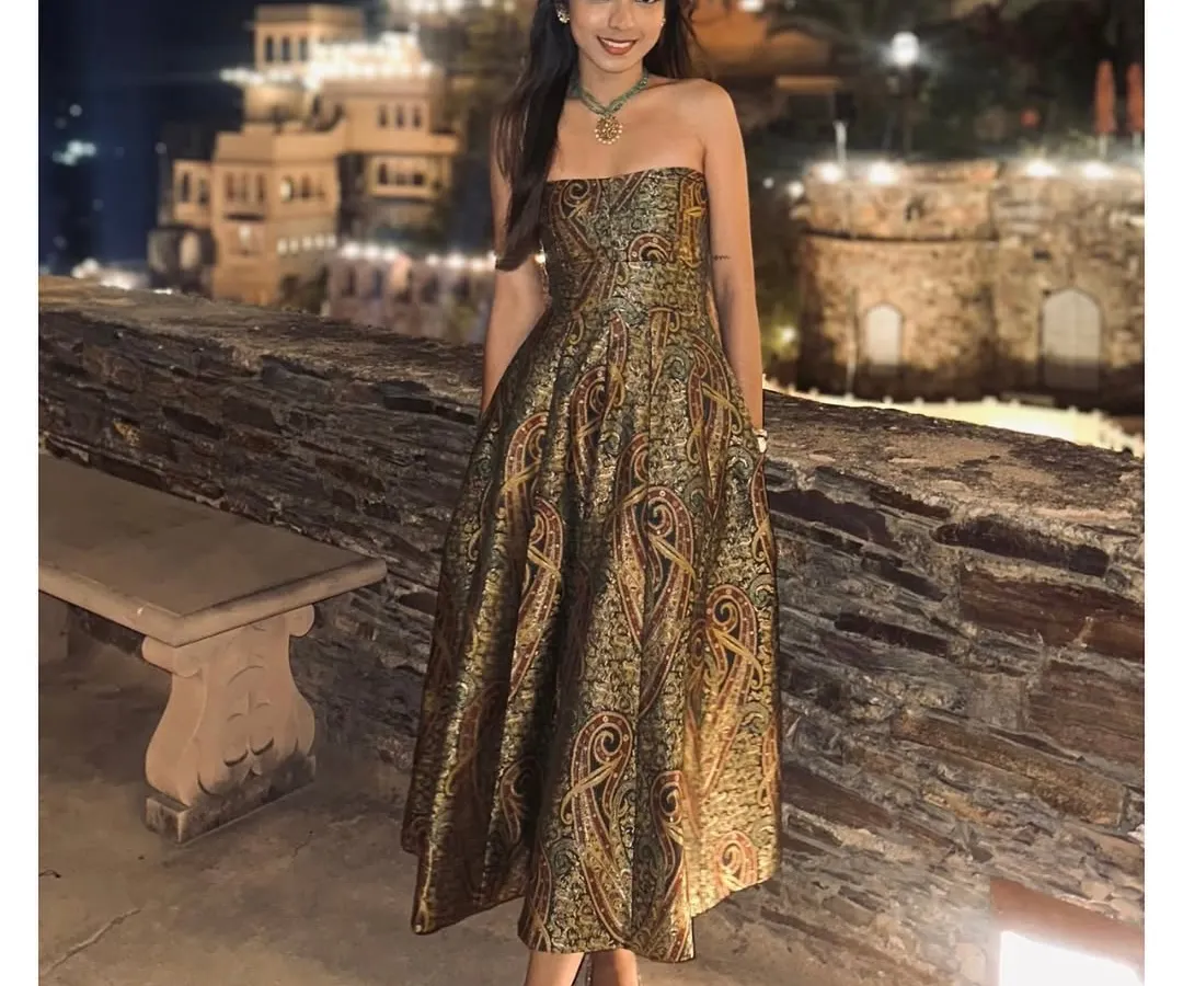 A client embodies pure elegance in her custom-designed strapless brocade dress at a destination event. The rich, paisley-patterned fabric and impeccable fit showcase our dedication to creating luxurious, memorable evening wear for any special occasion.