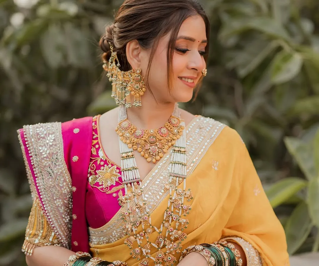 A radiant Maharashtrian bride in a stunning yellow and pink Nauvari saree. I created a soft, elegant updo to complement her traditional jewelry and nath, ensuring she felt comfortable and beautiful on her special day.