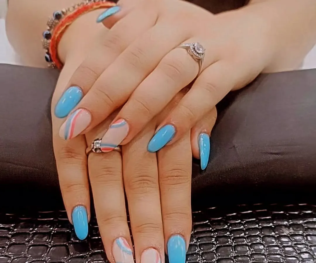For a fun and modern look, I combined solid sky blue gel polish with a negative space swirl design on these oval-shaped nail extensions. This style is perfect for anyone who wants a pop of color with an artistic touch.