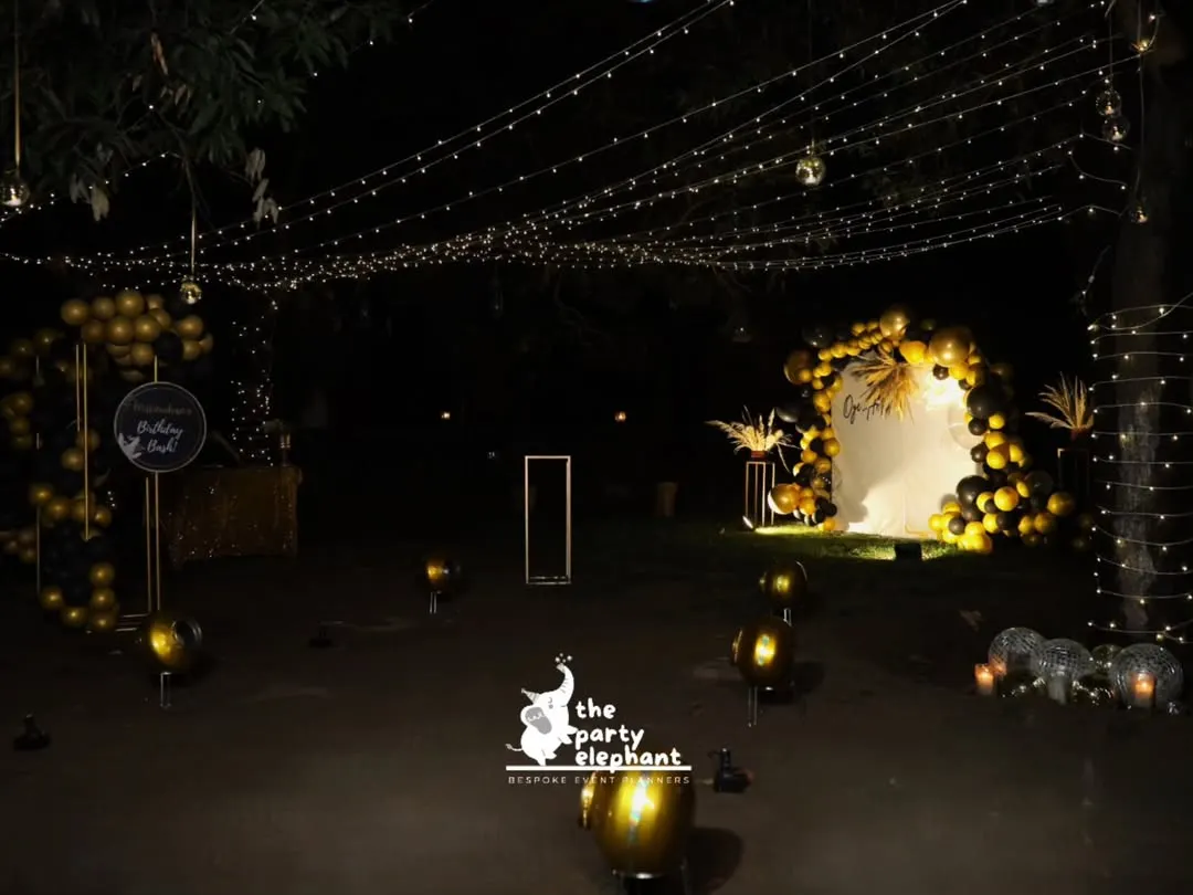 For this milestone 40th birthday, I transformed an outdoor space into a luxe, atmospheric lounge. A canopy of fairy lights, a dramatic black and gold balloon arch, and scattered floor balloons created a sophisticated and magical setting for an evening celebration.