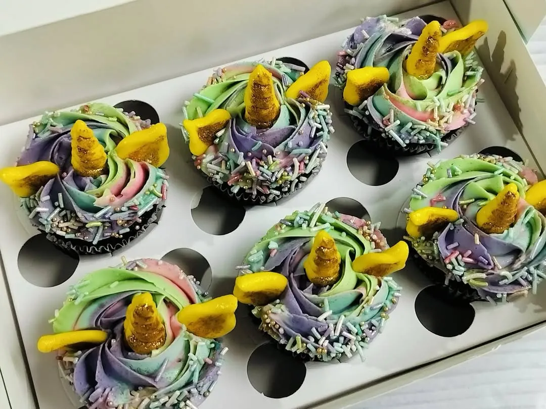 These magical unicorn cupcakes are one of my most requested designs for kids' parties. Each chocolate cupcake is decorated with a beautiful pastel rainbow swirl of buttercream, edible sprinkles, and a golden fondant horn and ears, making them a truly enchanting treat.