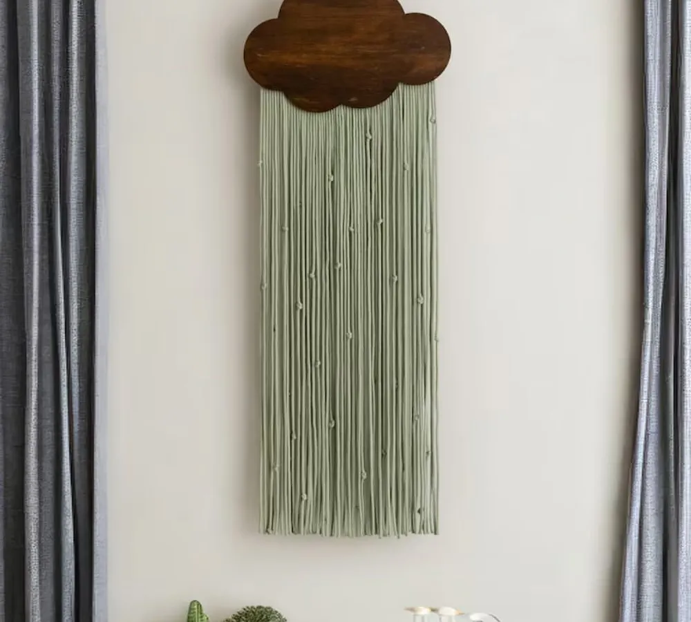 Introduce a touch of serene charm with our cloud-shaped macrame tapestry. Pictured here in a calming sage green with a dark wood finish, this piece adds a soft, dreamy element, making it a perfect wall sculpture for a bedroom, living area, or nursery.