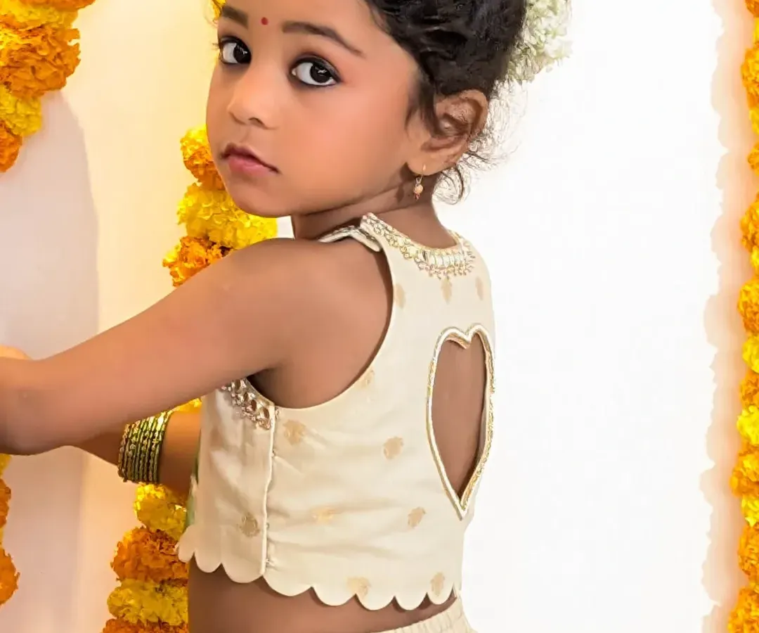Every detail is designed with care and a touch of playfulness. This view showcases the charming heart-shaped cutout on the back of our hand-painted blouse, adding a modern and delightful surprise to the traditional silhouette.
