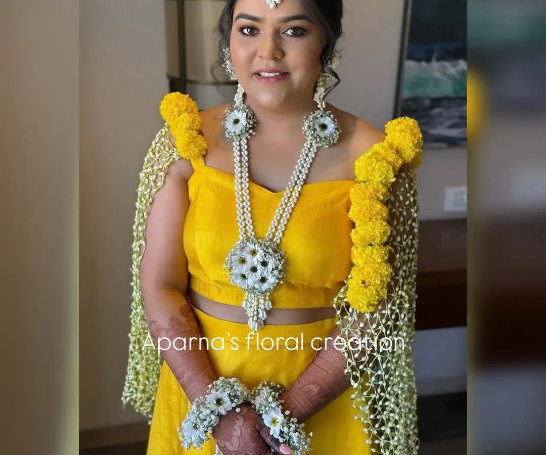 For a Haldi ceremony, bright and happy colors are a must. I created this stunning floral set with vibrant yellow flowers and baby's breath, including unique floral sleeves (bajuband) that drape over the shoulders for a truly special look.