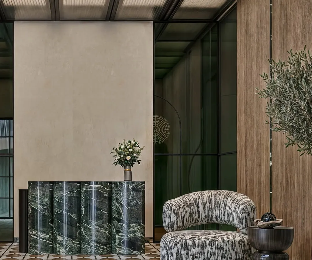 The reception area is the first impression of your company. For this Kolkata office, we designed a calm, sophisticated lobby using a fluted green marble desk, patterned flooring, and an abstract armchair to create a welcoming yet impressive entrance for visitors.