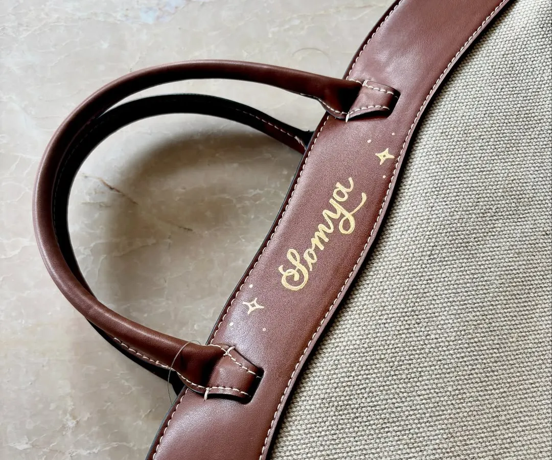 This shows my paint pen calligraphy on the leather strap of an H&M tote bag. I use a steady hand to create beautiful, flowing script, turning a simple bag into a one-of-a-kind accessory. Each design is sealed to ensure it lasts.