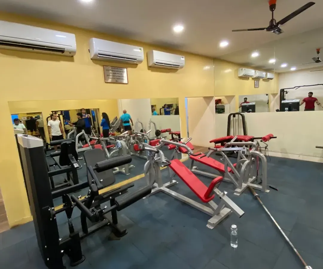 Here is a look at our indoor strength training zone. The space is clean, air-conditioned, and equipped with a variety of machines for a full-body workout, including bench presses and weight stations, all reflected in the full-wall mirrors that help you check your form.