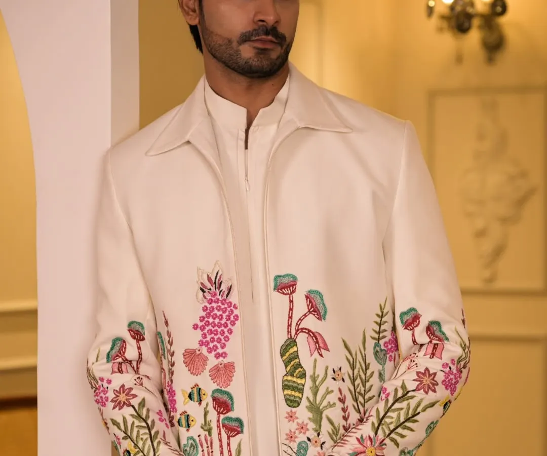 This ivory coord set, featuring vibrant floral hand-embroidery, is designed for daytime celebrations. It offers a fresh, modern take on traditional groomswear, perfect for a Sangeet or Mehendi ceremony.