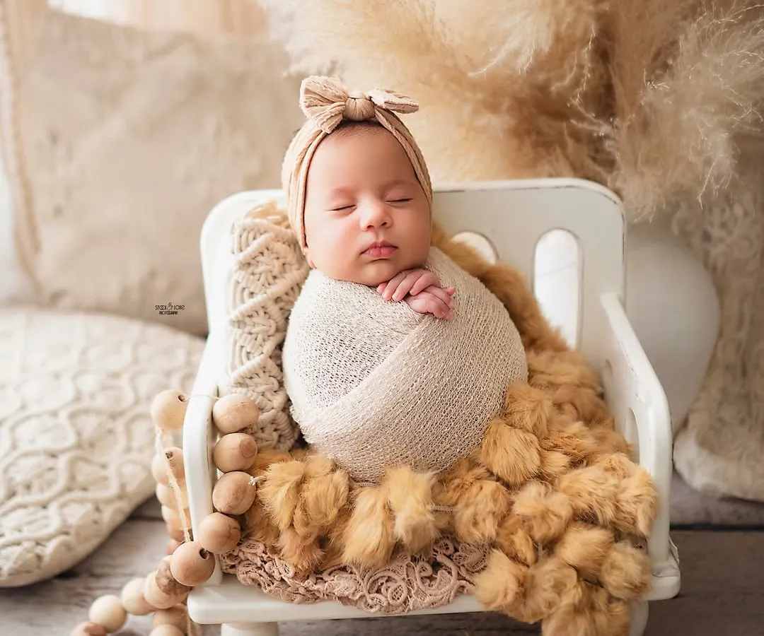 There is nothing more precious than a sleeping newborn. I specialize in creating these peaceful, dreamy portraits, ensuring your baby is safe, comfortable, and beautifully captured. This boho-themed setup with soft, neutral tones and natural textures is perfect for timeless newborn photos.
