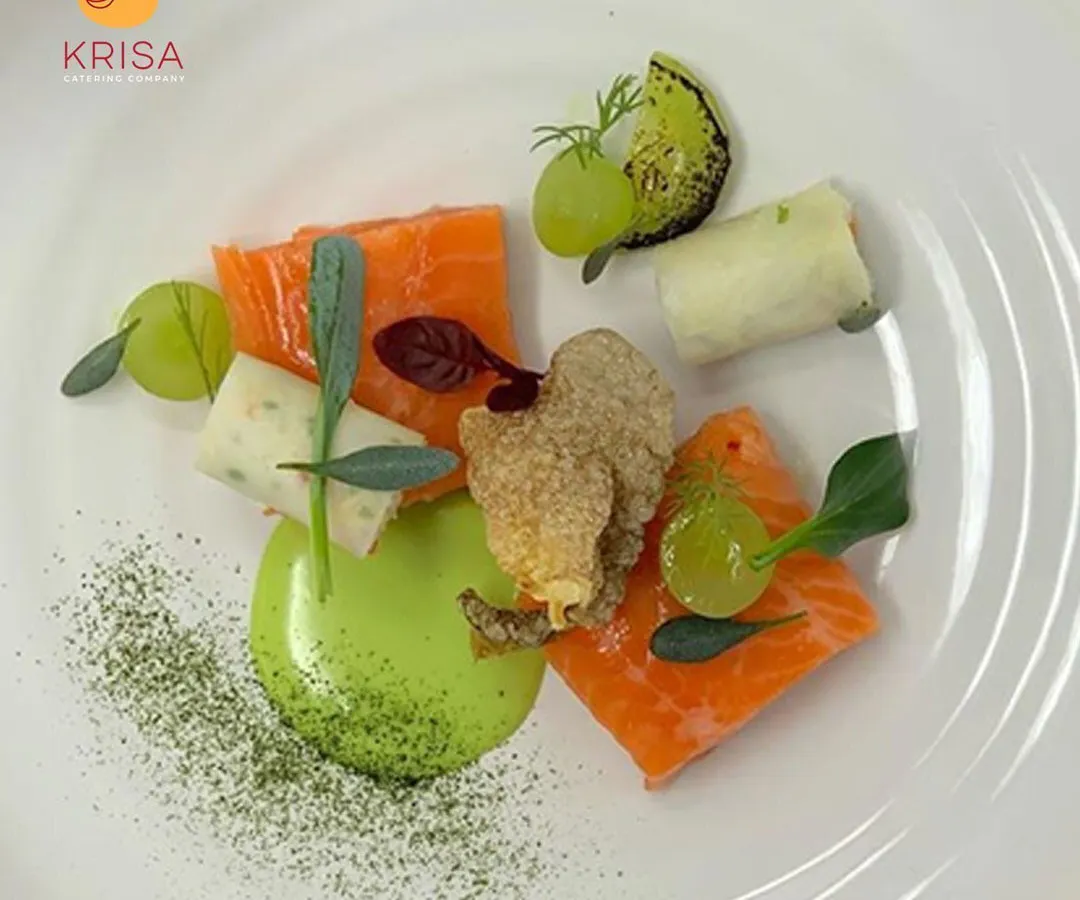 This is where culinary art meets corporate dining. A beautifully plated dish of cured salmon with avocado puree and fresh greens, showcasing the fine-dining experience we can create for your special events.