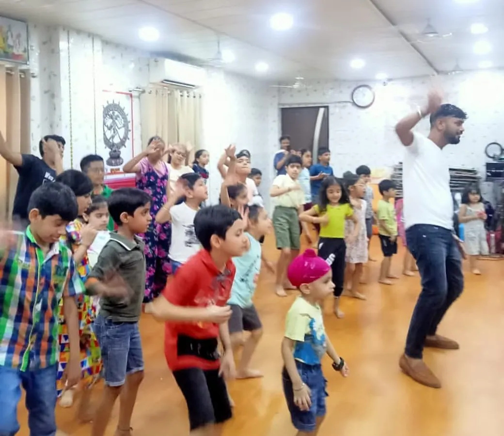 Our kids' fitness classes are all about joyful movement. An instructor leads a group of enthusiastic children in an energetic dance routine during our summer camp, making exercise feel like a party.