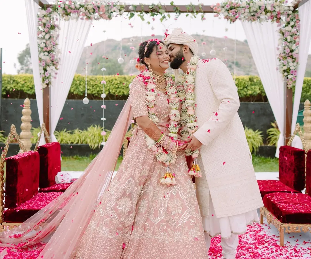 Pure elation under a shower of petals. This is the peak of the celebration, a vibrant, joyous moment from a beautiful North Indian wedding ceremony that we captured in all its colorful glory.