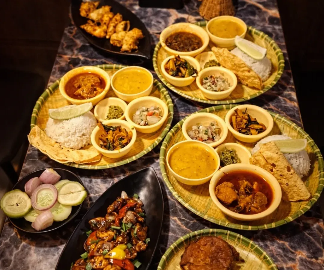 This is what we mean by 'barkat' or abundance. A table full of our thalis and starters, ready for friends and family to share. You can see our Assamese thalis, pork dishes, and fried starters, a true feast from the Northeast.