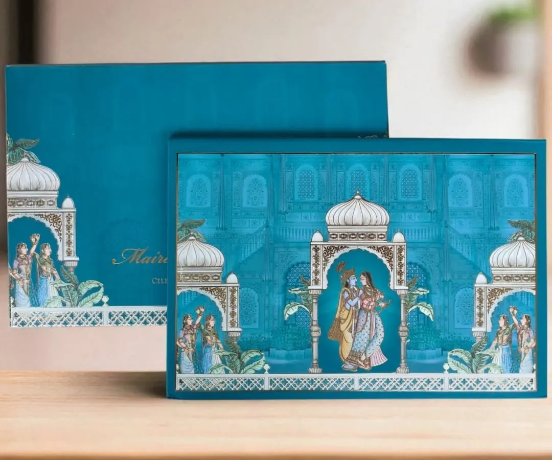 I love bringing traditional art forms to life, like in this Pichwai-themed invitation box. The vibrant teal and intricate illustrations of Radha and Krishna create a piece that is both culturally rich and modern in its presentation.