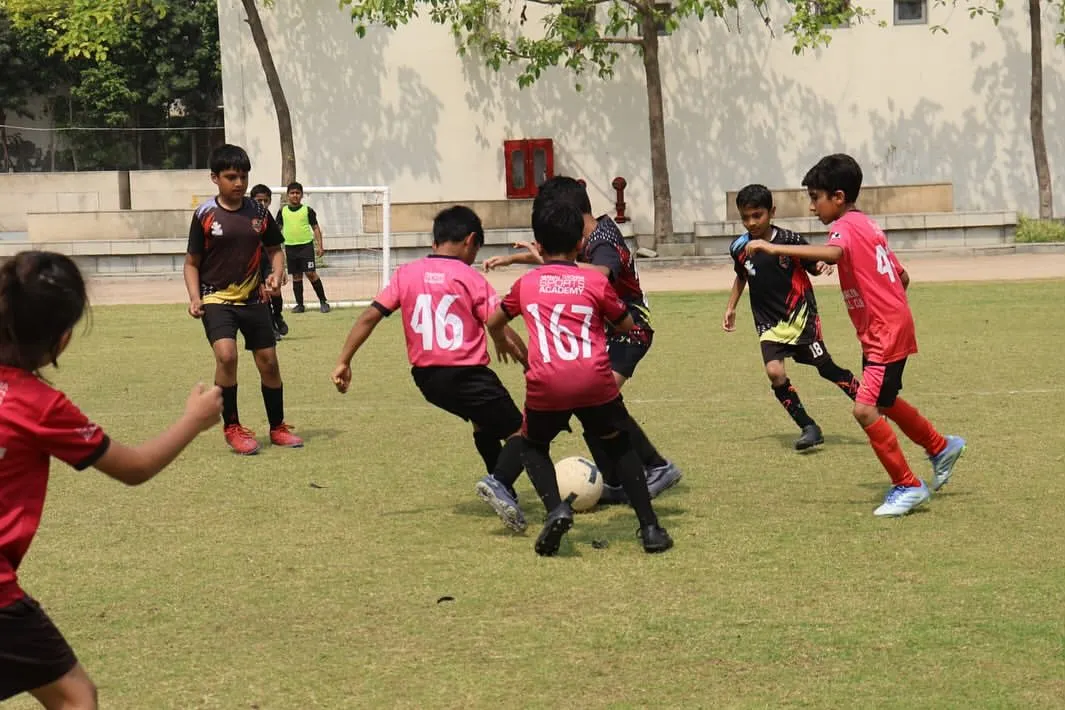 The intensity of a real match is where lessons are truly learned. Our players are locked in a battle for possession during a DFA League game, demonstrating the tactical awareness and competitive spirit we instill in every training session.