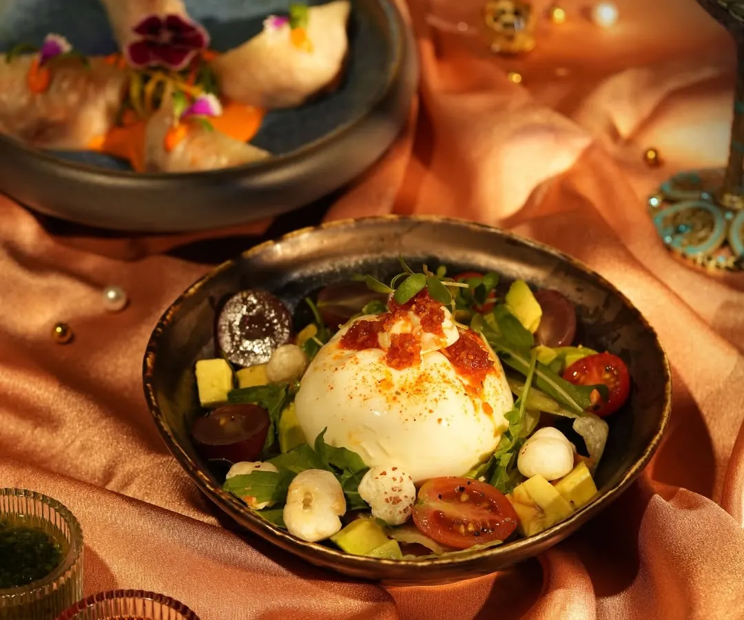 A plate that demands your full attention. Here, a creamy Burrata sits among fresh greens, ripe tomatoes, and avocado, ready to be dressed with infused oils. It’s a quiet performance of flavour and texture.