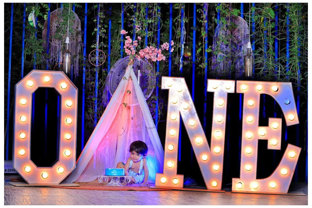 Celebrate your baby's first milestone with a memorable cake smash or birthday photoshoot. We provide themed setups like this one, complete with large 'ONE' marquee letters and a safe, fun environment for your little one.