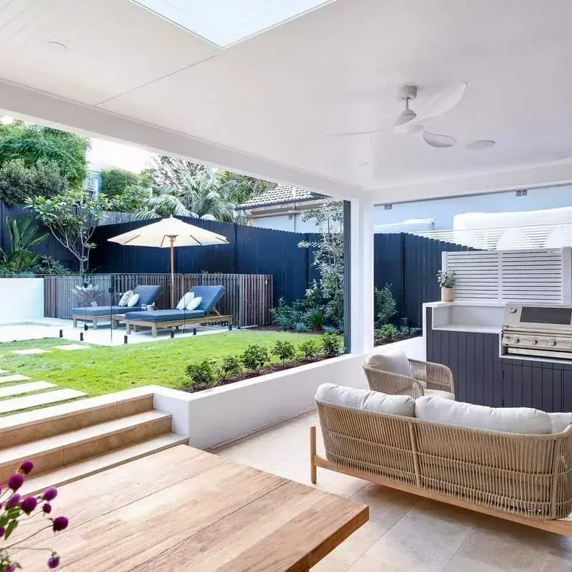 This project shows how I integrate different zones into one seamless outdoor living area. It features a covered patio with a sofa, an outdoor kitchen and grill, and a poolside lawn for a complete backyard experience.