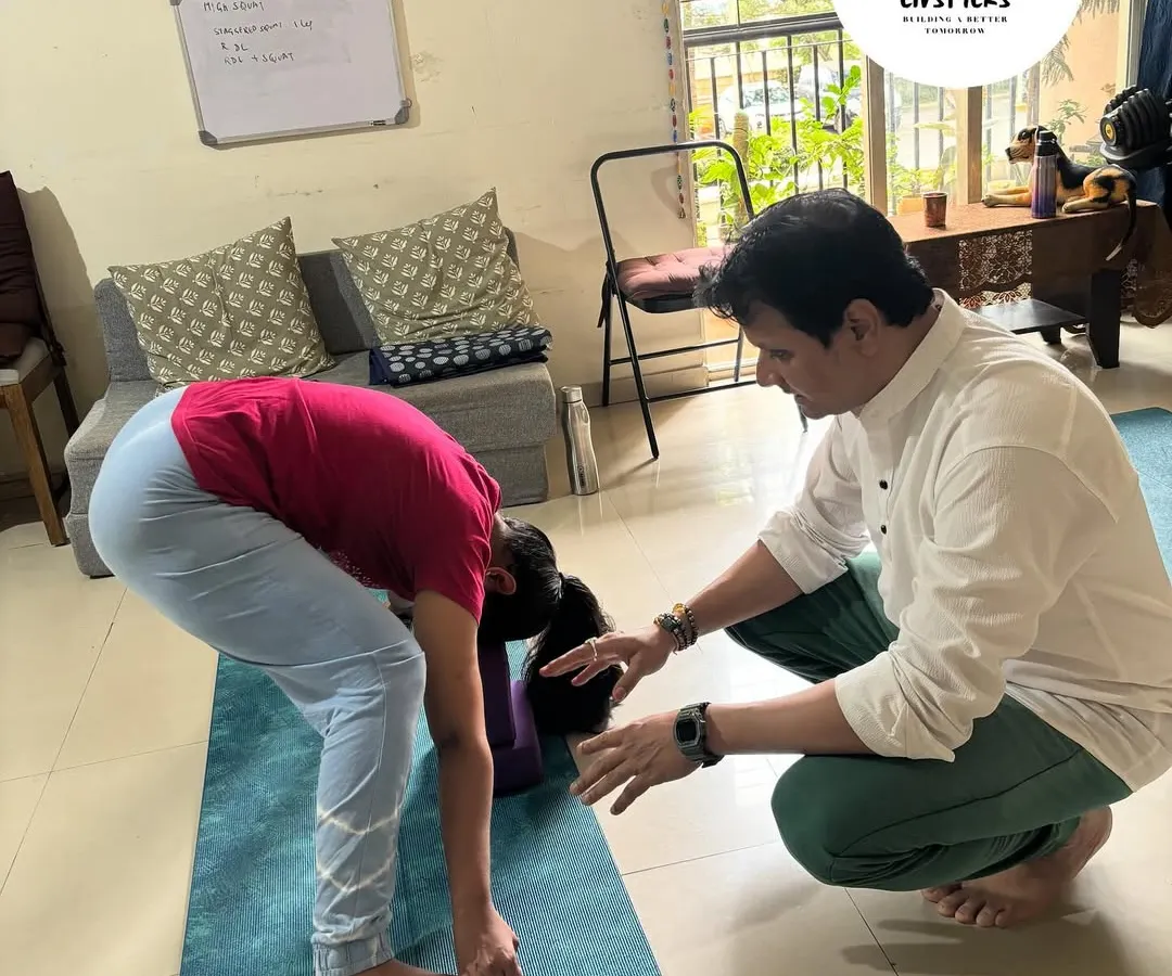 I believe in a hands-on approach. Here, I'm guiding a client to ensure proper alignment in a forward bend, which is crucial for preventing injury and maximizing the benefits of the pose. This personal attention is at the core of my coaching philosophy.