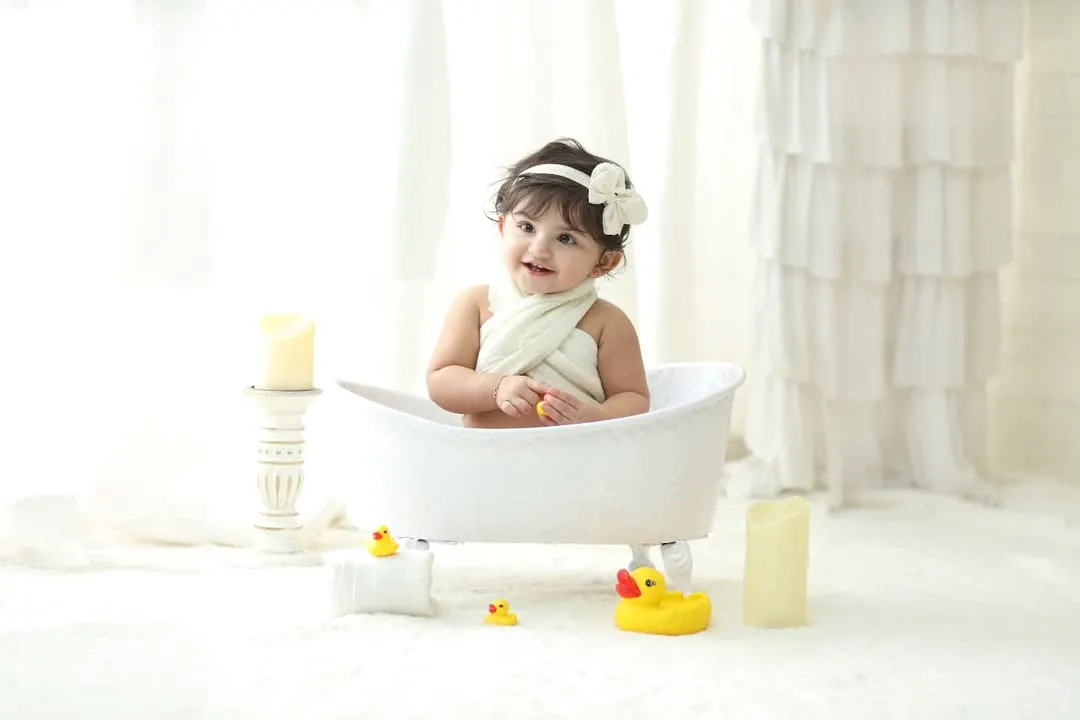 Our signature bathtub photoshoots are a favorite among parents and toddlers. This clean, all white setup with classic rubber ducks creates a simple yet adorable portrait that is timeless and full of fun.