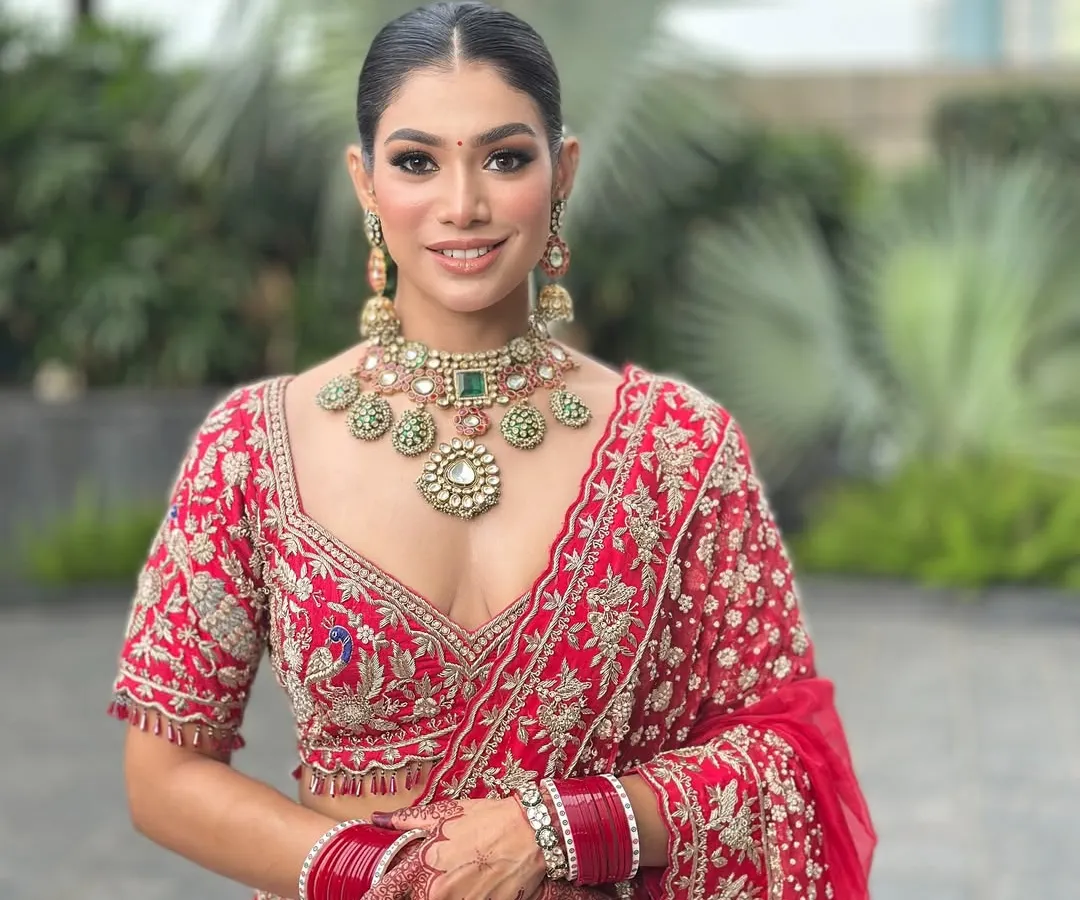 A full portrait of my beautiful bride in a classic red lehenga. I focused on creating a luminous skin finish and defined eyes to complement her traditional wedding attire and heavy jewellery, ensuring she looked absolutely regal.