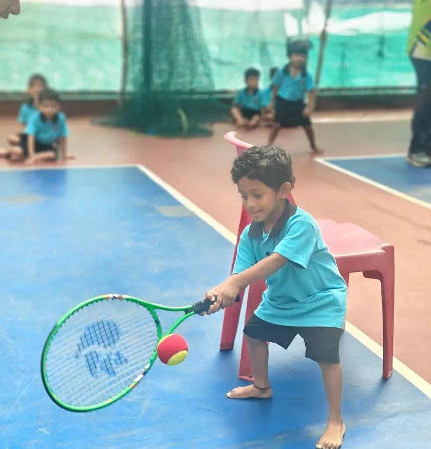 It all starts here. A young player in our Mini-Tennis program learns the fundamentals of a forehand, focusing on making clean contact with the ball. We make learning fun and effective from the very first swing.