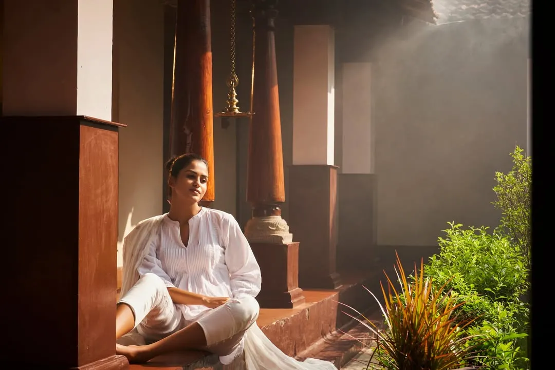 This is the feeling of post-treatment bliss. Here, a guest soaks in the serene, misty atmosphere of our heritage verandah after a rejuvenating Ayurvedic therapy session. This moment of quiet reflection is an essential part of the healing process, allowing the body and mind to absorb the benefits of the treatment.