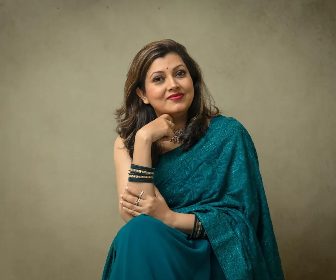 An elegant portrait celebrating personal style. Here, we used a simple, neutral background to let her beautiful teal saree and confident presence shine, creating a timeless and graceful image.