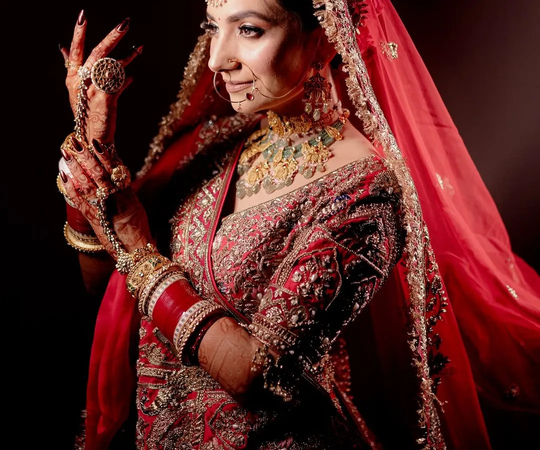 I believe a bridal portrait should be more than just a photo; it should be a reflection of her soul. Using dramatic lighting, I focused on this bride's serene expression and the intricate details of her red lehenga and jewelry, creating a powerful and timeless image.