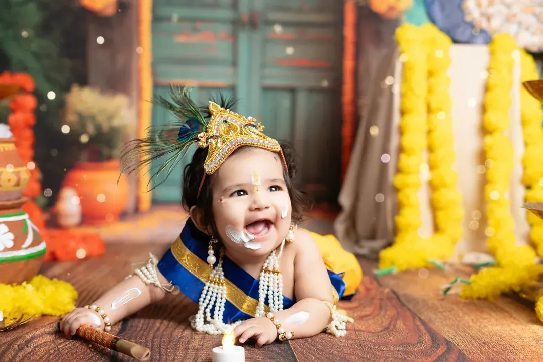 Capturing the playful spirit of a little one in our popular 'Little Krishna' themed photoshoot. This joyful moment, complete with a mischievous, buttery smile, showcases how I bring creative concepts to life for memorable child portraits.