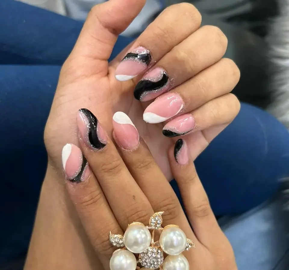 For a modern and chic look, I designed this abstract nail art using a soft pink base with bold black and white waves, accented with a hint of black glitter. This style is done on durable acrylic extensions, perfect for making a statement.