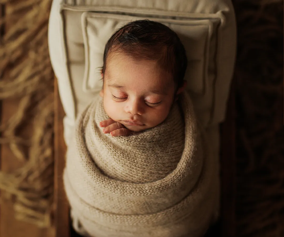 I believe in the beauty of simplicity. This is a classic newborn portrait, where your baby is safely wrapped and peacefully dreaming in a rustic, cozy bed. The earthy tones and soft textures create a serene atmosphere, letting your little one's perfect details shine.