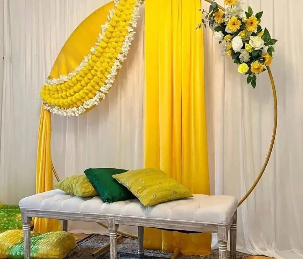 For this haldi ceremony, I used a modern gold ring frame decorated with traditional marigold garlands and bright yellow drapes. The comfortable bench seating makes it perfect for photos and for the main rituals.