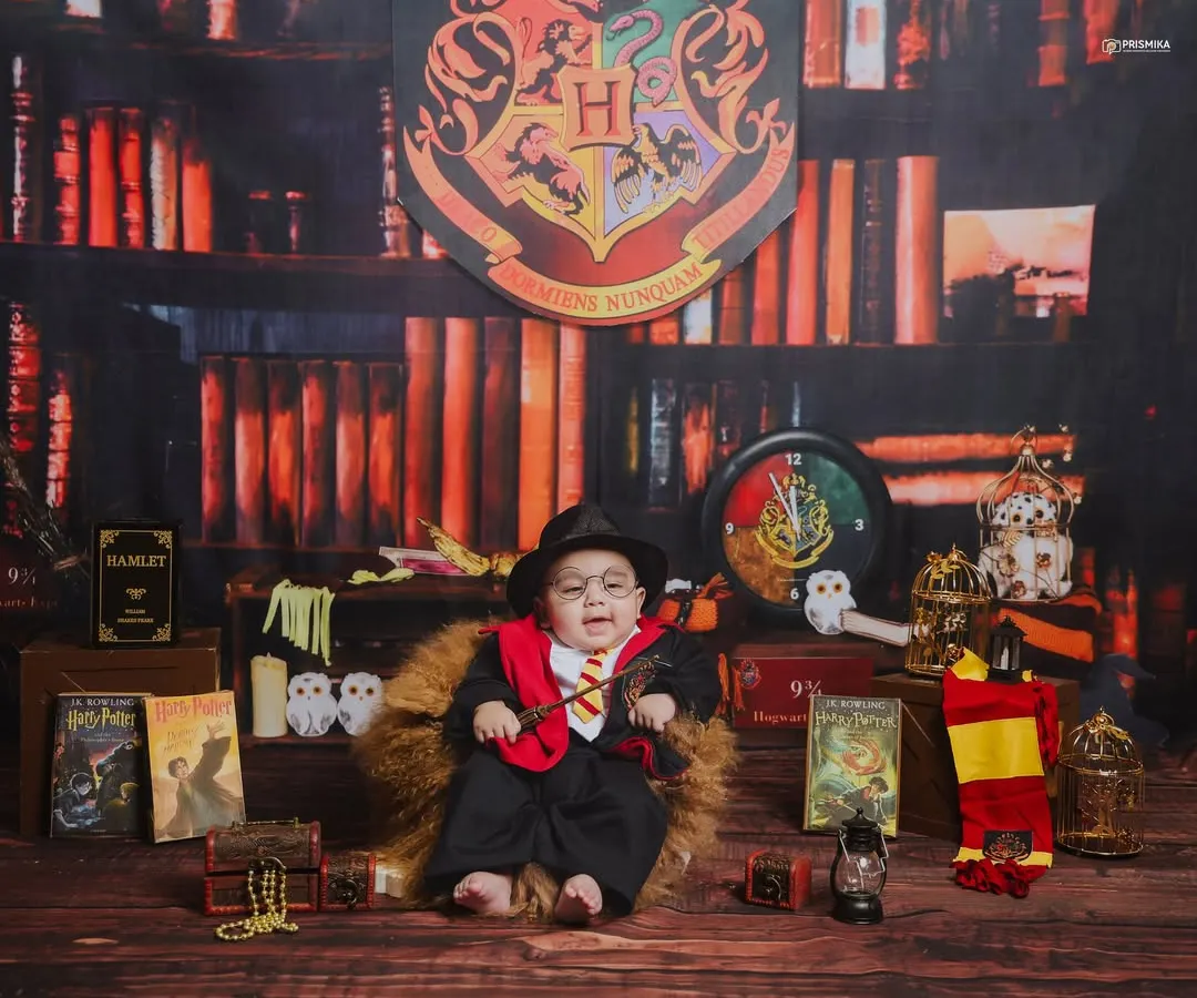 We believe in making magic. For this baby wizard photoshoot, we built a complete Hogwarts-inspired set, filled with classic books, house scarves, and a magical wand to create an enchanting portrait for this little one.