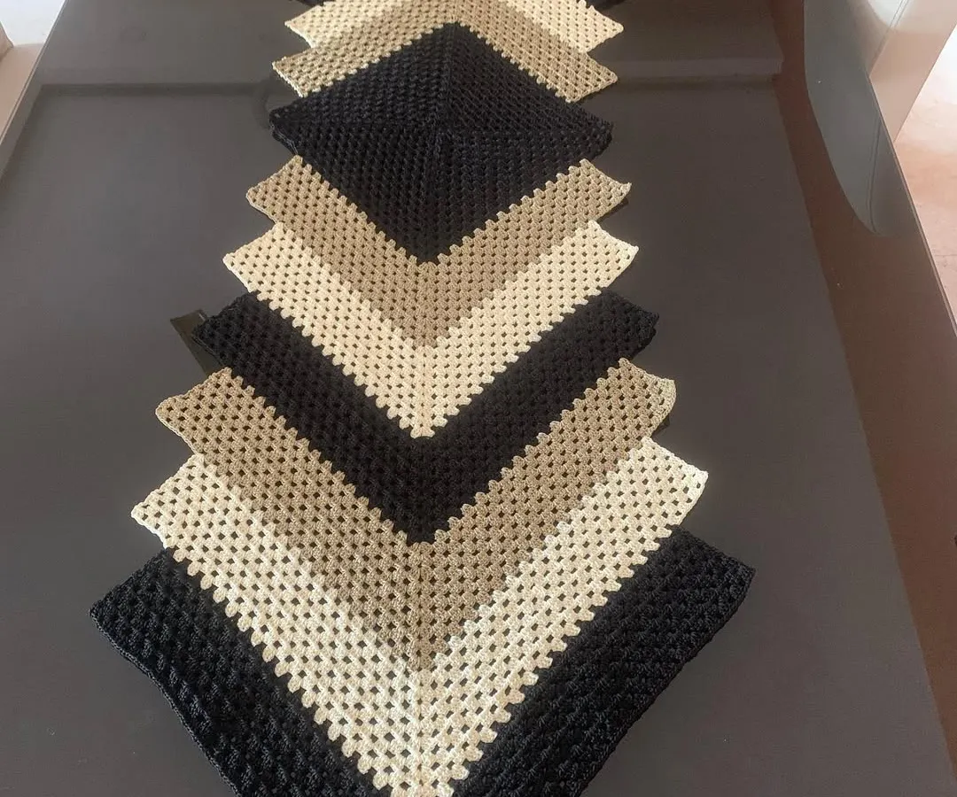 This modern chevron table runner is a real statement piece. I created this design in neutral shades of black, beige, and cream to add a touch of class to a contemporary dining or coffee table.