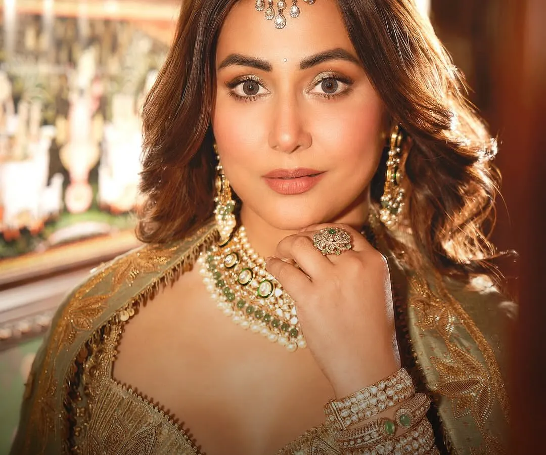 The radiant Hina Khan embodying the spirit of a modern bride in a complete JBR set. The look features a bespoke polki and pearl necklace, matching earrings, a maang tikka, and stacked kadas, all handcrafted to create a story of timeless elegance.