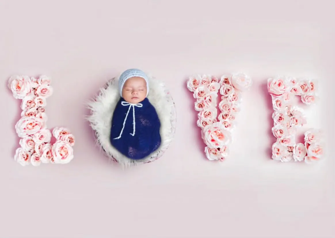 Look at this little angel, all snuggled up. I created the word LOVE using soft pink flowers to frame the baby, making for a super sweet and classic newborn portrait. It’s a simple, beautiful way to celebrate your new love.