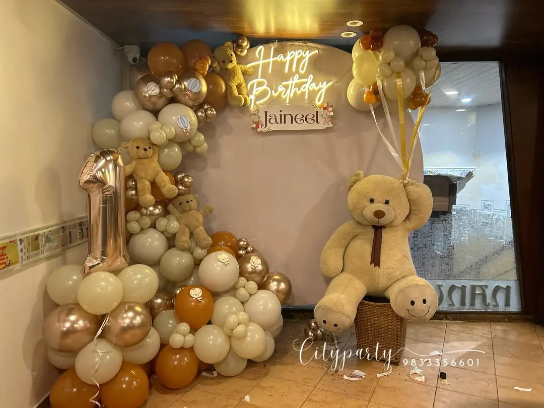 For this first birthday, we created a full teddy bear theme with a custom neon sign, a large teddy bear prop, and a balloon arch in earthy tones of cream, brown, and rose gold.