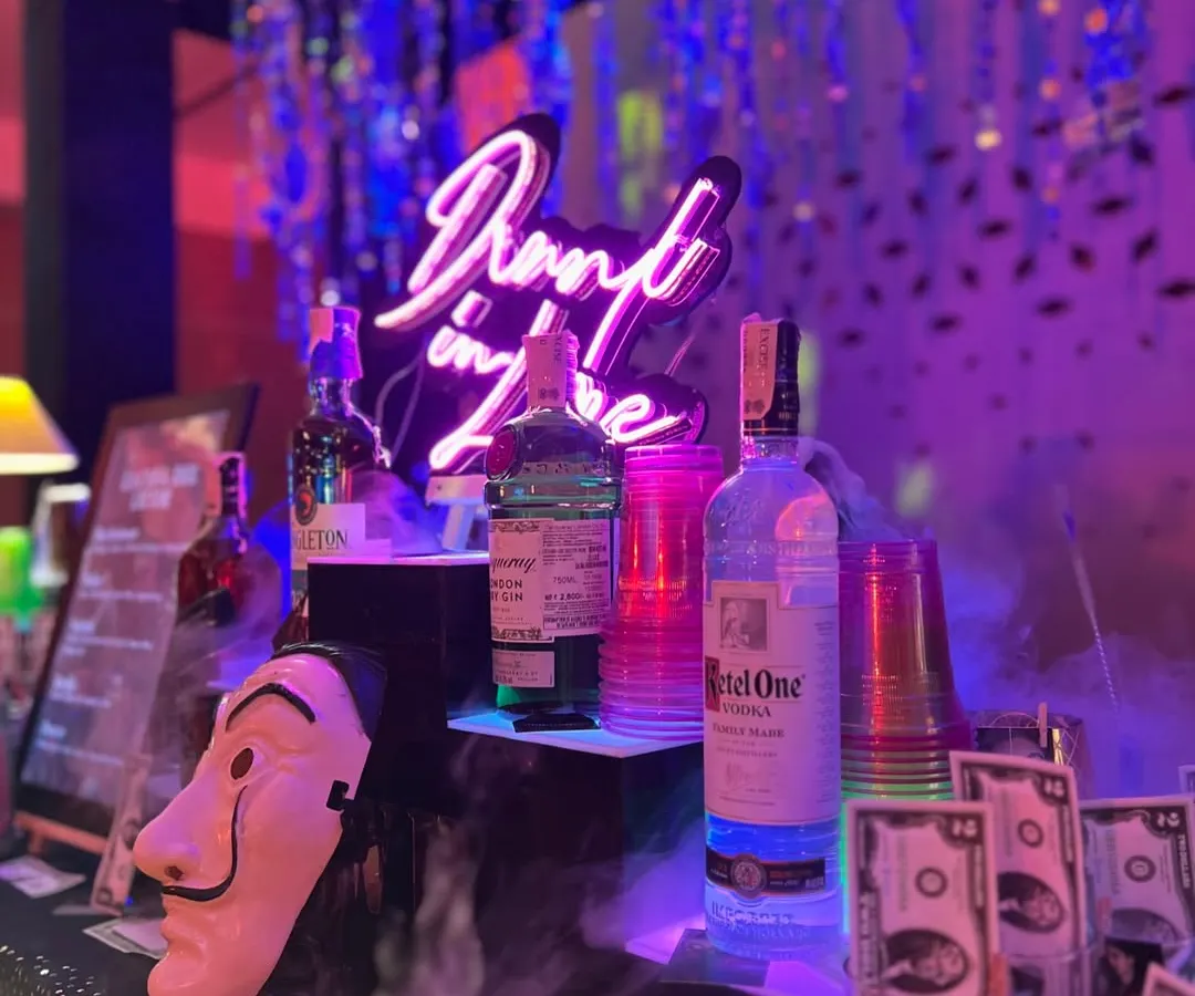 Our Money Heist themed bar in full swing. We bring the theme to life with details like Dali masks, prop money, and a custom "Drunk in Love" neon sign, creating an immersive experience for your sangeet or cocktail night.