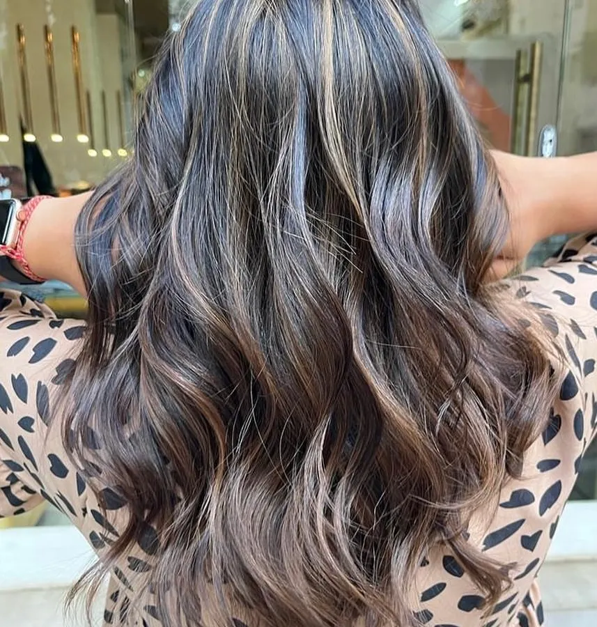 A perfect example of a sun-kissed caramel balayage on a dark base. I hand-painted these highlights to create a seamless, natural-looking blend that adds warmth and dimension. The final style with soft waves really makes the caramel tones pop.