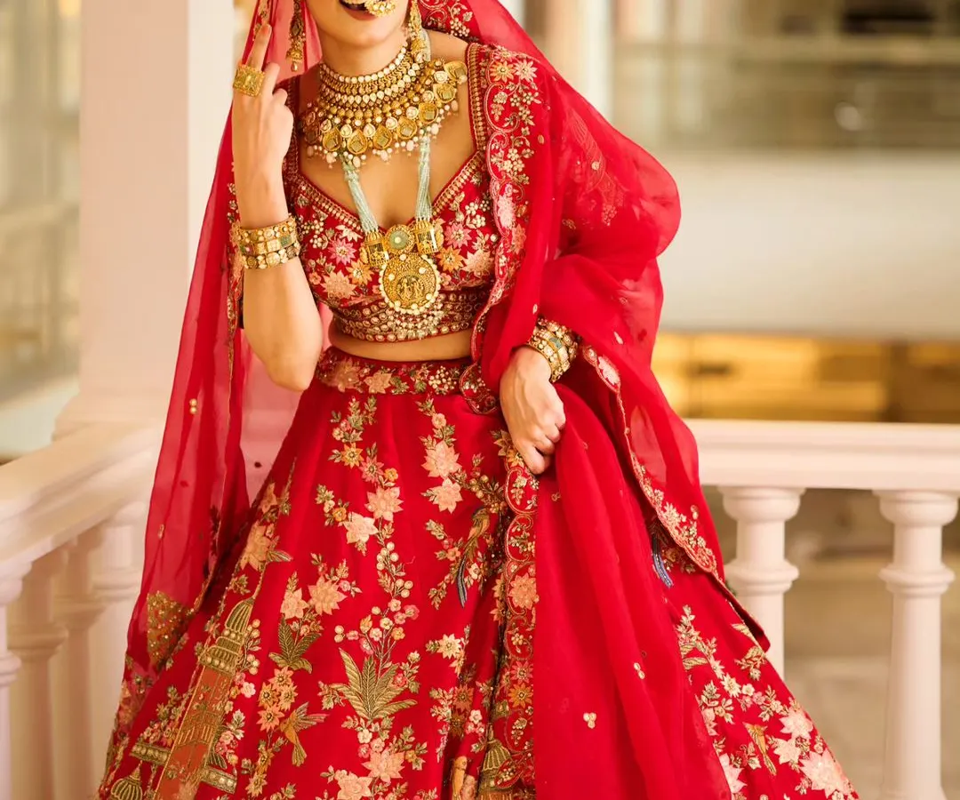 For this bridal campaign, the goal was to create a moment of pure joy. The vibrant red lehenga stands out against the elegant architecture, and the natural, happy expression of the model makes the entire scene feel authentic and aspirational for any bride-to-be.