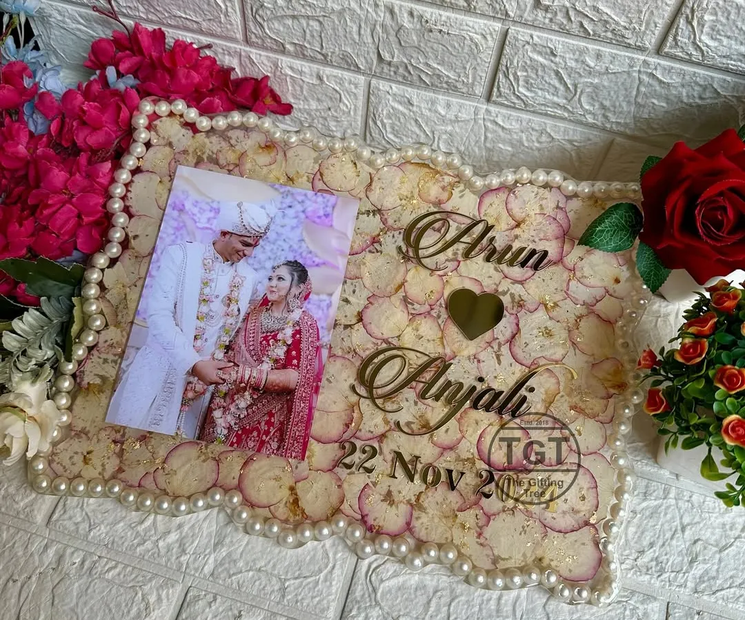 We can turn your wedding varmala and favorite photo into a beautiful memory frame. This 12x16 inch resin frame uses the original flower petals as a backdrop and pearls from the varmala for the border, creating a complete and sentimental keepsake.