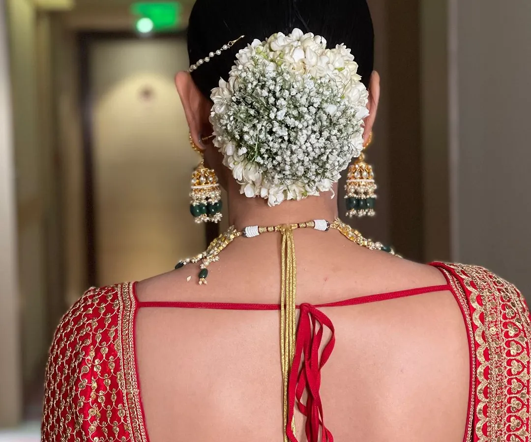 This is a classic for a reason. I crafted this traditional bridal bun and adorned it with a full circle of fresh baby's breath gajra, creating a clean, elegant, and timeless look for the main wedding ceremony.