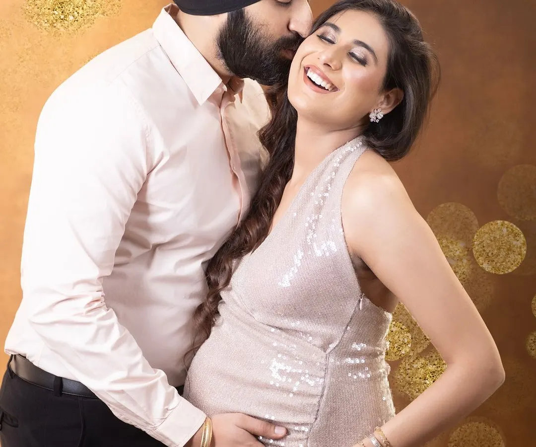 The joy of expecting, shared between partners. This candid moment captures a genuine laugh, showcasing the love and excitement of the journey. The glamorous sequin gown adds a touch of sparkle to this beautiful memory.