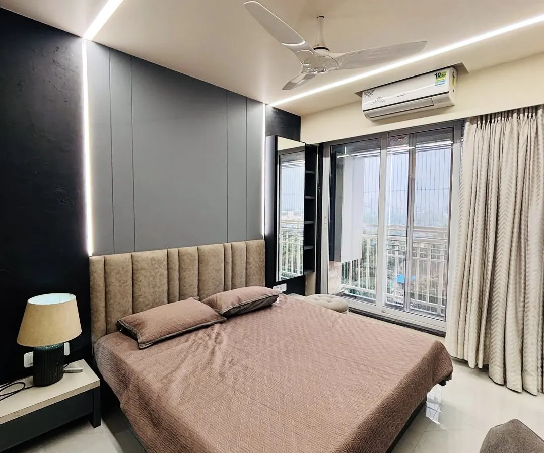 I create bedrooms that are true retreats. This project features modern dark paneling, ambient strip lighting along the ceiling and headboard, and an upholstered bed to create a cozy, sophisticated atmosphere.