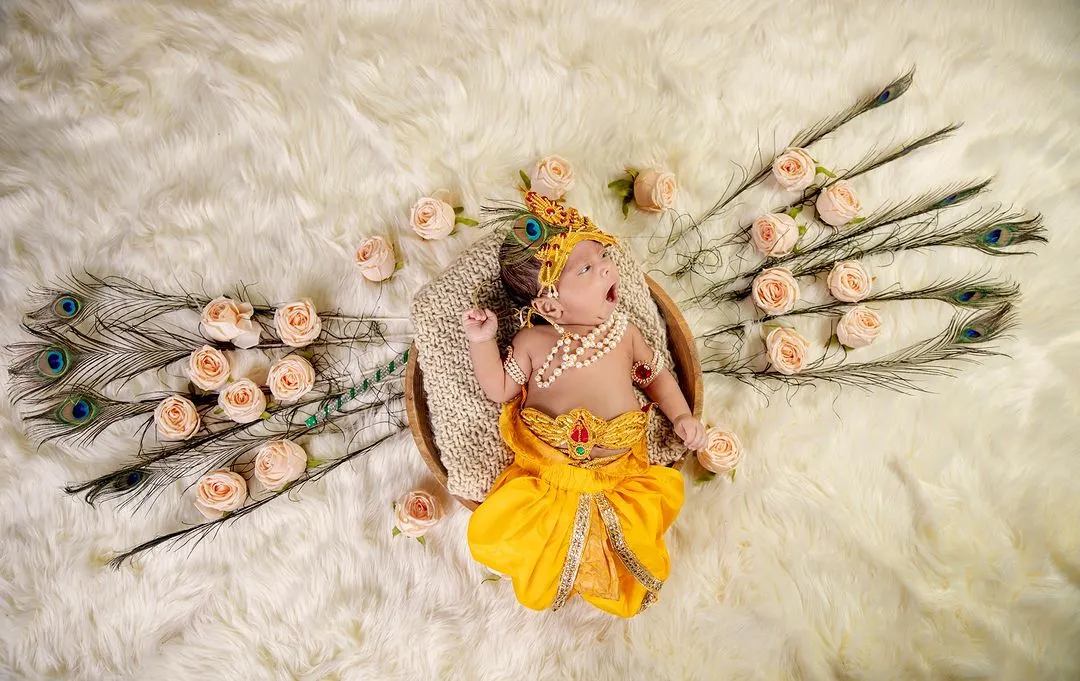 A sleepy yawn from a tiny Krishna. This is an example of our themed newborn photoshoots, where we use beautiful props like peacock feathers and soft wraps to create a magical and safe setting for your baby.